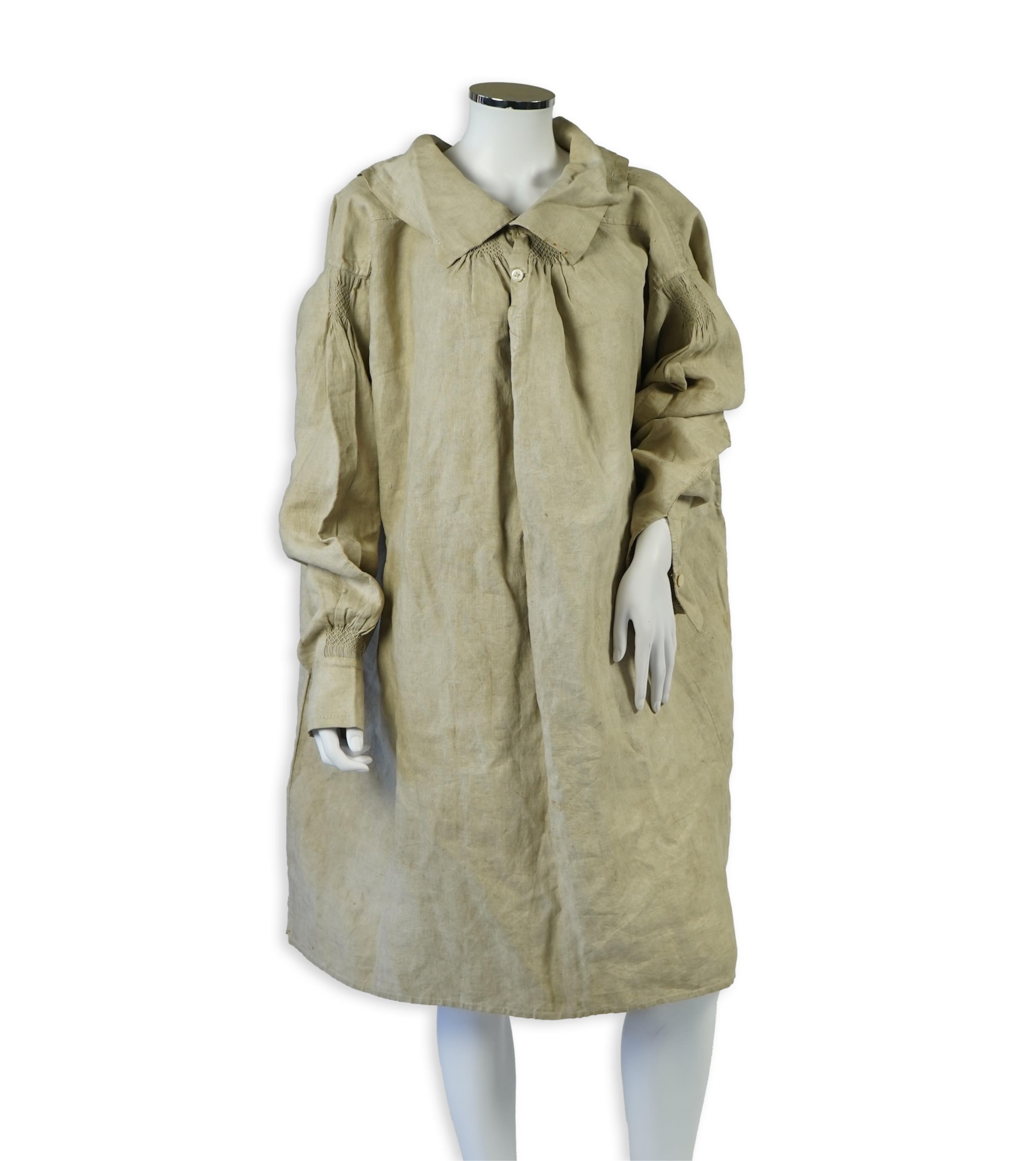 A 19th century heavy linen Shepherd’s smock, with small smocked shoulders and front and back neck panels under collar., 97cm long. Condition - patched and small darn near top and minor wear, usual for age and use.
